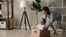 Young mom and small daughter play crazy creative games at home, mother barefoot run ride cute kid girl while she sit inside of big carton box, family fool around enjoy playtime at new modern warm flat - Powered by Shutterstock - Get 15% off with code: PIKWIZARD15