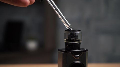 a person fills his vape with a special liquid