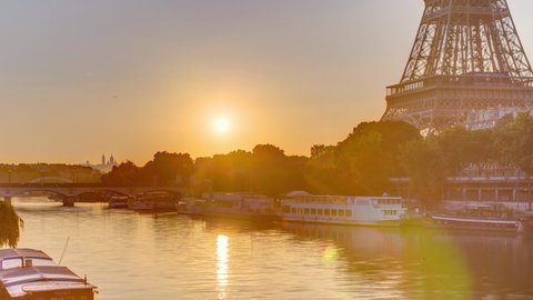 Eiffel Tower and the Seine river at Sunrise timelapse, Paris, France. Morning view from Bir-Hakeim bridge with reflections on water