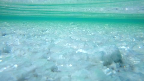 Salar de Uyuni underwater view. Camera reveals salty crystals under the thin layer of water in the famous Bolivian salt flat Salar de Uyuni