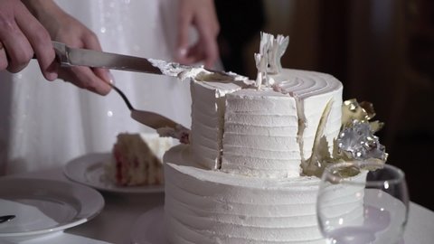 Cutting a wedding cake with a knife. Dessert, the couple, the bride and groom cut