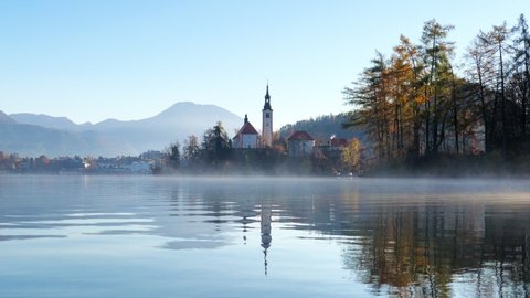 Beautiful video of Bled lake landscape with view to the Castle of Bled and Church of Saint Martin at autumn morning, Slovenia.