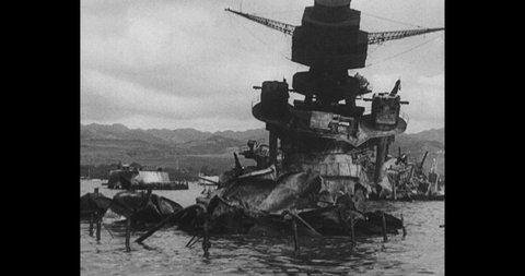 1941 Pearl Harbor: Wreckage of boat. Smoke and flames rise from water.