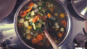 stirring a pot of vegetable soup top view. Minestrone soup boiling in the pot. Vegetarian healthy meal for dinner. Ready vegetable meal for lunch, hot and cozy soup for dinner at home - Powered by Shutterstock - Get 15% off with code: PIKWIZARD15