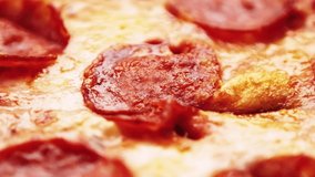 Mozzarella pizza with pepperoni sausage baked in oven for dinner,filmed in close up 4k video clip.Delicious Italian fast food in closeup.Melted mozzarella cheese,spicy meat on crusty bread dough