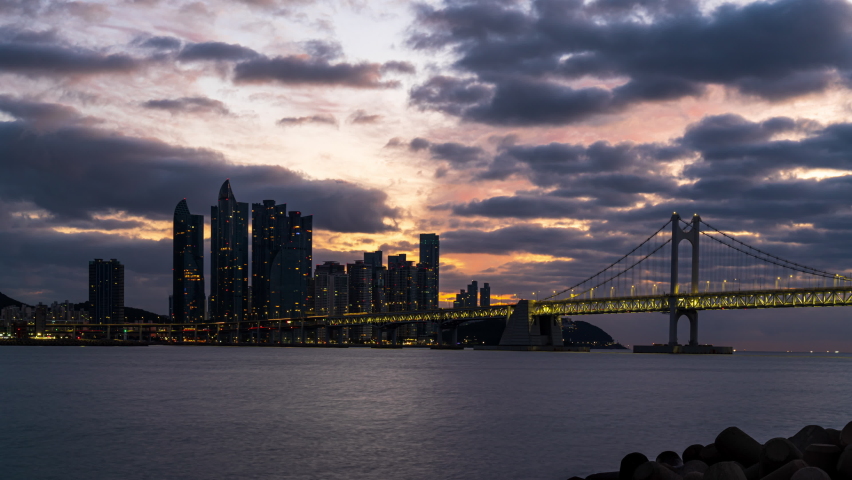Timelapse 4K sunrise over the downtown skyline of Busan city as viewed from across the sea popular Destinations in Busan,South Korea
