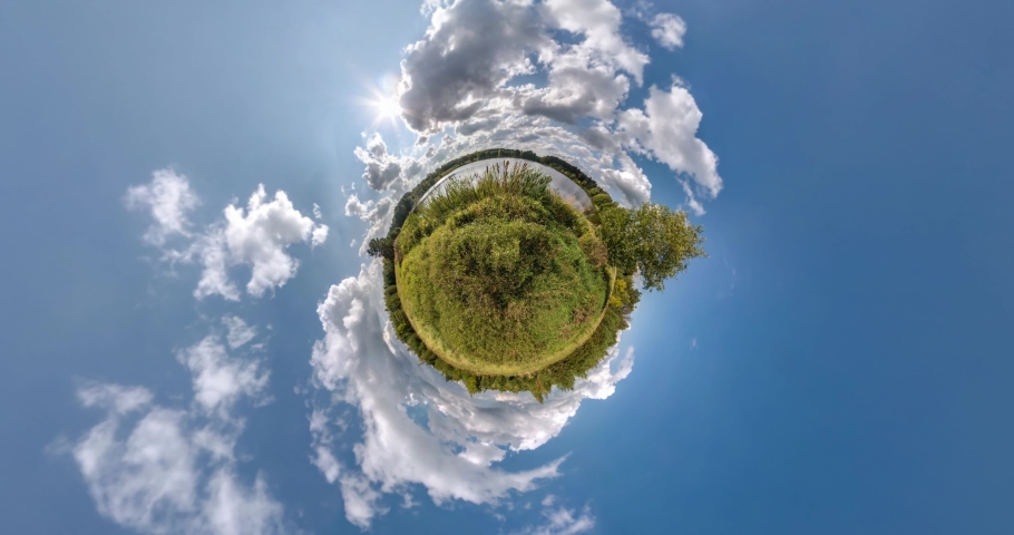 revolves on road among fields with beautiful blue sky with white clouds. green little planet transformation with curvature of space. loop rotate Royalty-Free Stock Footage #1062718330