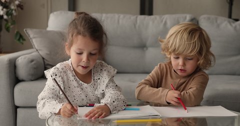 Two little friends siblings spend free time at home drawing with colorful pencils in sketchbook chatting enjoy common hobby and leisure activity. Kid development children education, friendship concept