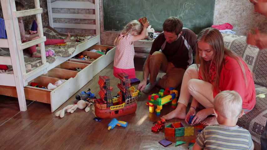 A friendly family with children playing toys at home.