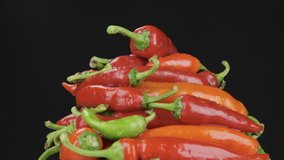 Slow motion. Raindrops falling on a rotating pile of hot peppers. - Powered by Shutterstock - Get 15% off with code: PIKWIZARD15
