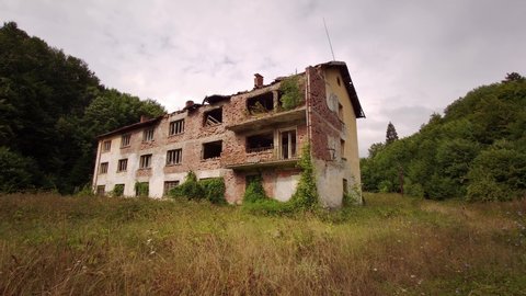Post-apocalyptic view of an abandoned building from communist time overtaken by nature near an old mine in the Balkan mountain of Bulgaria.