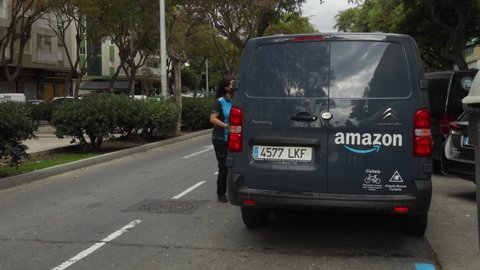 Malaga, Spain; 11/21/2020; Woman working in amazon -  amazon prime delivery van - amazon home delivery 