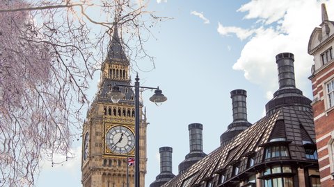 Time lapse of big ben tower or clock during a sunny cloudy day. There is the tower in close up and the clouds in background