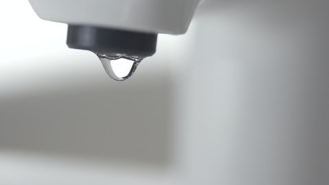 Water Dripping From The Bathroom faucet  Tap. Water Leaking, drop by drop save water concept slow motion