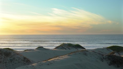 Sand dunes on the beach and ocean view at sunset. Oceano, California