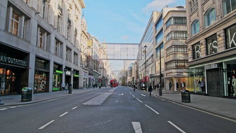 London , England / United Kingdom (UK) - 11 05 2020: London in Covid-19 Coronavirus lockdown with quiet empty roads at Oxford Street with closed shops shut at the popular shopping high street