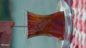 Drinking tea with glass of traditional Turkish tea on the beach.Video for the vertical story.