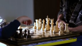 Grandmother playing chess with her grandson at home. close up view. Slow motion footage. Shot video.