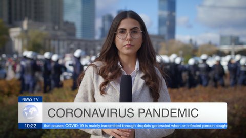 Caucasian Young Woman Journalist Looking At Camera And Presenting Breaking News TV About Coronavirus Pandemic On Street Outdoors Lot Of People Police In Background Pandemic City Protest And March