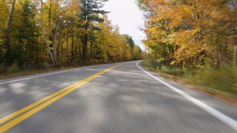 POV Driving a car on rural asphalt road with colorful trees in autumn