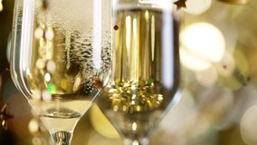 Flutes with Sparkling Champagne Wine over Golden Bokeh Blinking Background. Super Slow Motion
