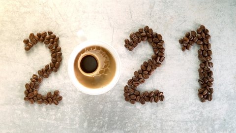 Coffee inscription of year 2021 with splashing liquid, super slow motion 