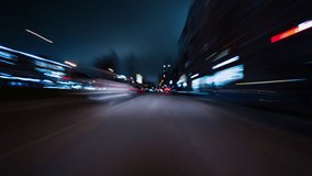 Beautiful motion timelapse of high speed drive on the night. Front view from the windscreen to the road with other cars and night city with skyscrapers and neon lights.