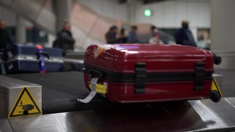 4k, Suitcase on luggage conveyor belt in the baggage claim at arrivals lounge of airport international terminal building. Luggage waiting area, journey concept-Dan