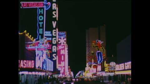 1960s: Film slate. Neon sign for the Sands. Neon signs from casinos, restaurants down strip in Las Vegas.