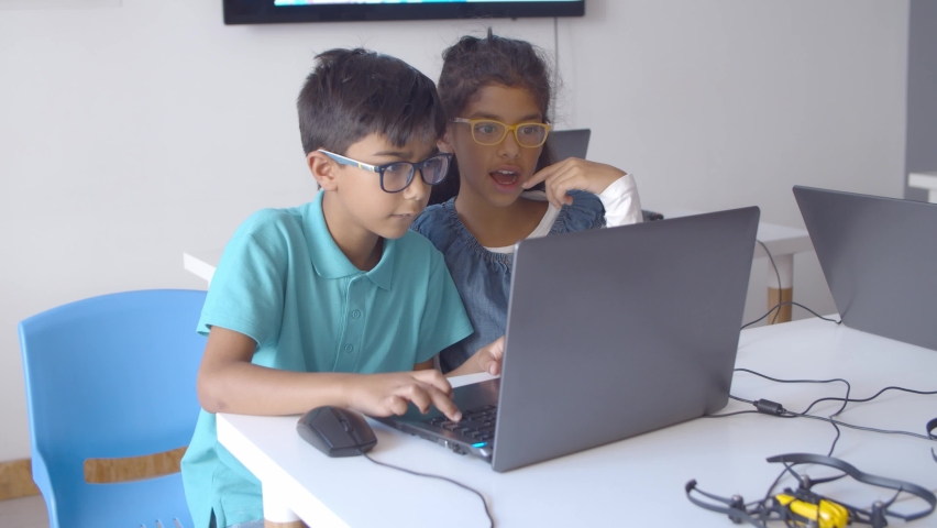 Two serious classmates in glasses working on task, using laptop in classroom. Static shot. Digital education concept | Shutterstock HD Video #1062785098