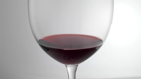 Red wine being poured into glass shot in slow motion 