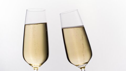 Slow motion footage of two champagne flutes against a white background 