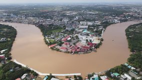 Aerial view over area of main city of Chachoengsao province show line and curve of big river name Bang Pakong. The area contain building of village and also agriculture zone during day time. 