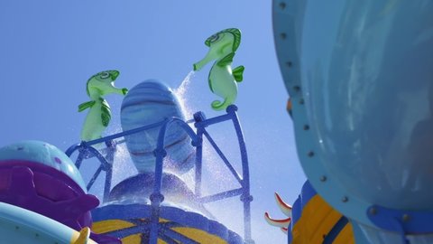 Animated characters in the aqua park. seahorses are filling the bucket with water. the filled bucket spills down and the slow motion shooting of the spilling water from the top.