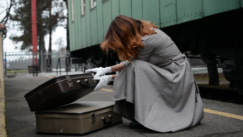 Girl with two suitcases at the railway station