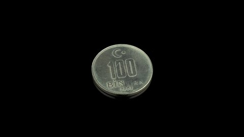 Turkish 100 bin lira from 2002 coin on a black background.