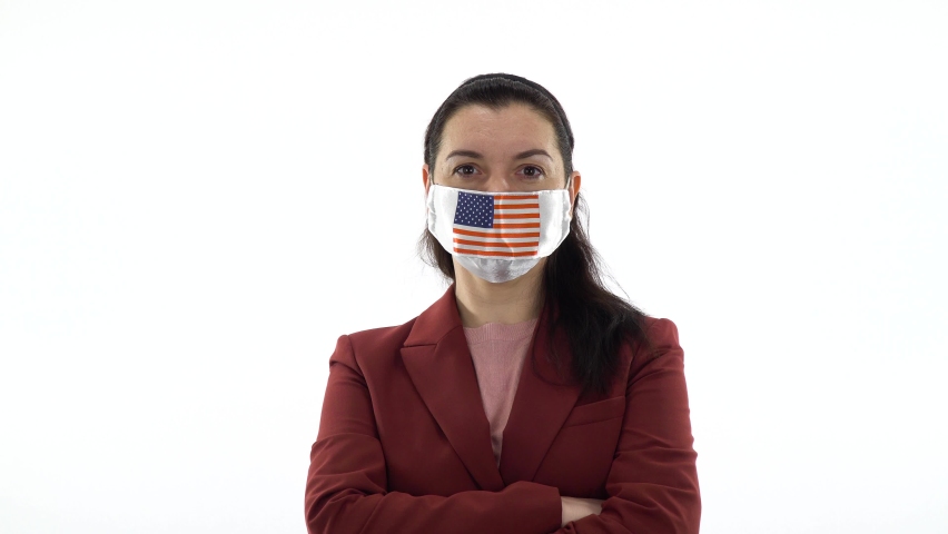 Virus and disease prevention concept. Pandemic and quarantine. A woman wears a protective medical mask with the image of the US flag. Image of USA flag on a medical mask. Mock up on white, copy space.