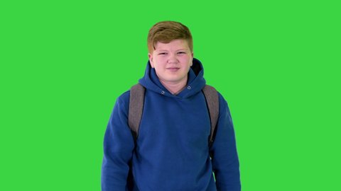 Overweight young man walking and taking off medical mask on a Green Screen, Chroma Key.
