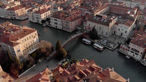 

Aerial view of the busy bridge near Venice. A drone panorama of the city overlooking the canal of the Adriatic Sea in northern Italy. A shot of people walking across the bridge from a drone. Sunset