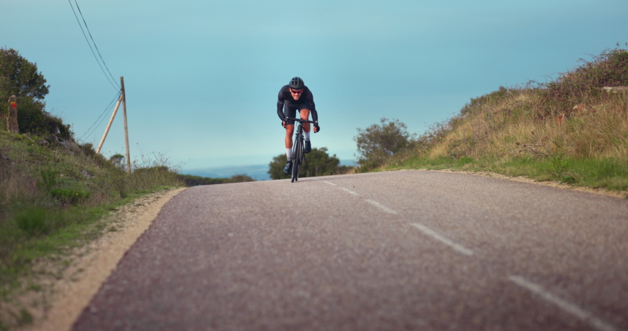 Professional cyclist struggling to ride bicycle uphill | Shutterstock HD Video #1062831073