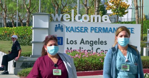 LOS ANGELES, CALIFORNIA, USA - NOVEMBER 17, 2020: Nurses with masks walking near Kaiser Permanente Medical Center on Sunset Boulevard in Hollywood during Covid-19 pandemic, Los Angeles California, 4K