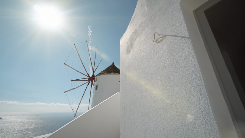 Panoramic view of windmill under summe sun shining in Oia in Santorini | Shutterstock HD Video #1062836443