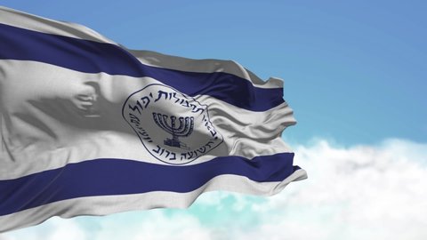The flag with the symbols of the Israeli security services and intelligence waving against the blue sky with clouds. Hebrew inscription, menorah image, selective focus, 
