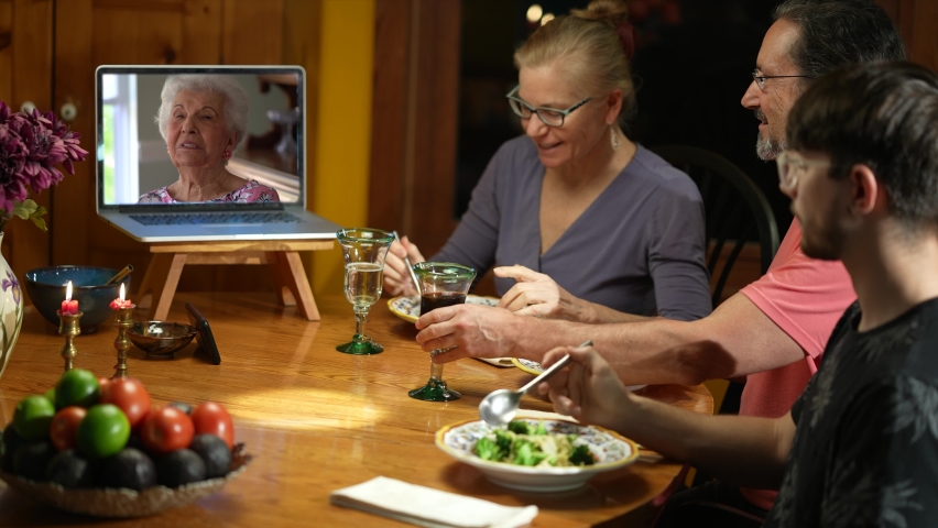 Family having a video call with grandmother during thanksgiving dinner, happy family greeting a remote guest. Concept of remote holiday meal. | Shutterstock HD Video #1062839653