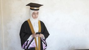 Arabian women using her mobile phone for a video call to celebrate her graduation occasion