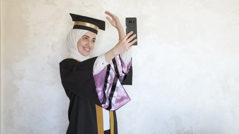 Arabian women using her mobile phone for a video call to celebrate her graduation occasion