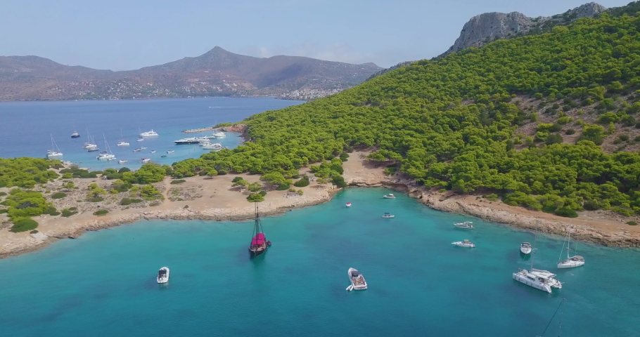 Ascending drone shot of moored yachts and catamarans on a beautiful bay for diving