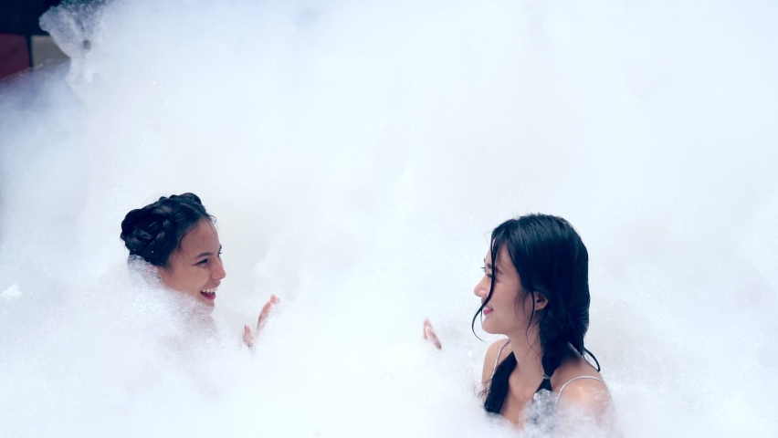 Girl playing in bubble pool with fun and joy . Summer people recreation .