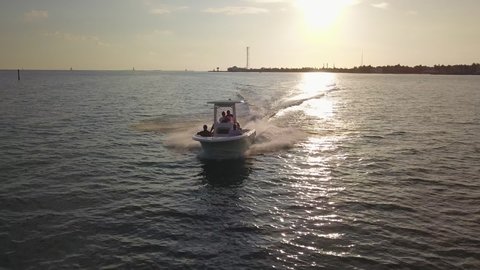 Friends riding on a center console at full speed near Key West Florida during sunset.