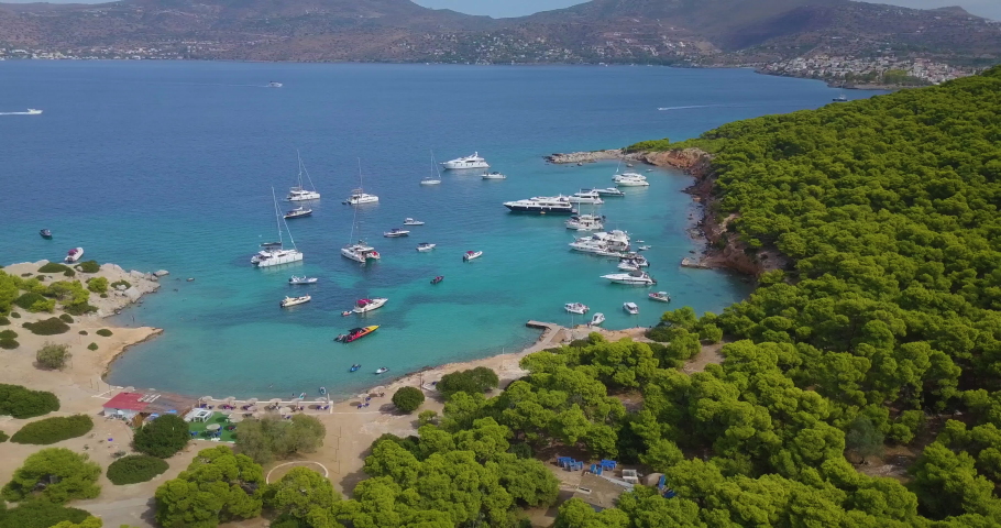 Ascending drone shot of moored yachts and catamarans on a beautiful bay for diving